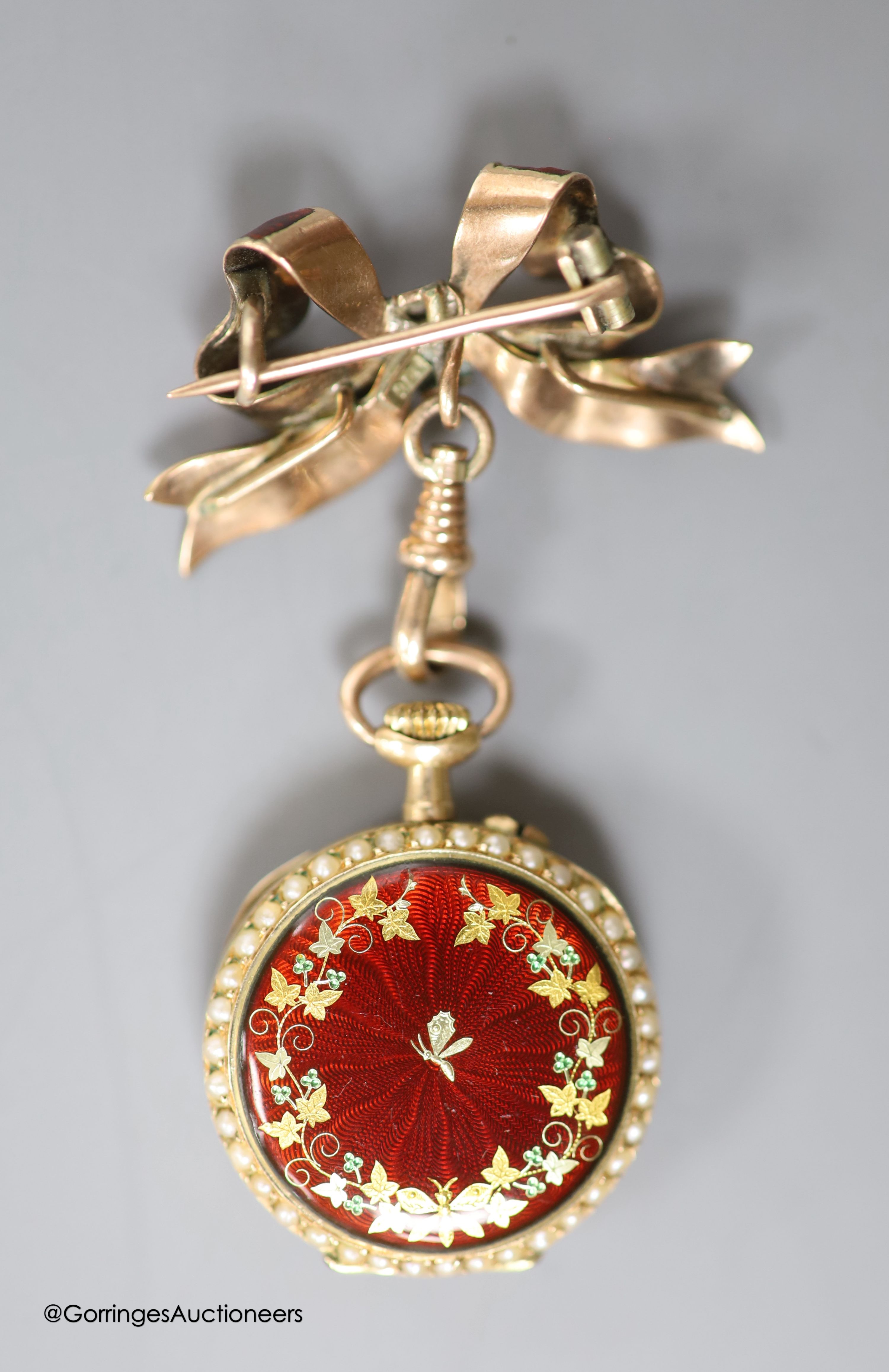 A lady's early 20th century 14k yellow metal, red enamel and seed pearl set fob watch(a.f.), case diameter 26mm, gross 15.5 grams, on a 9ct and red enamel bow brooch, gross 4.6 grams.